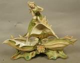 Lot 334  -  AMPHORA Porcelain Figural Group. Art Nouveau Woman sits on shell form base. Not  marked. -- Dimensions:  H: 10 inches: W: 12.75 inches: D: 6 inches --- 