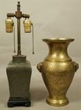 Lot 340  -  2pc Asian Metal Lot. 1). Pewter Urn Table Lamp. Carved ebonized wood base. 2). Handled Brass Vase with animal handles. Incised with flora & cloud design.-- Dimensions:  H: 18 inches: W: 4.25 inches --- 