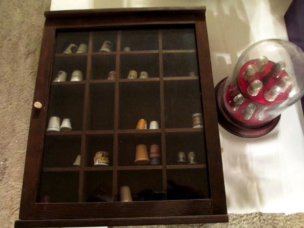 Shadow box with porcelain thimble collection, silver thimbles inside a dome..