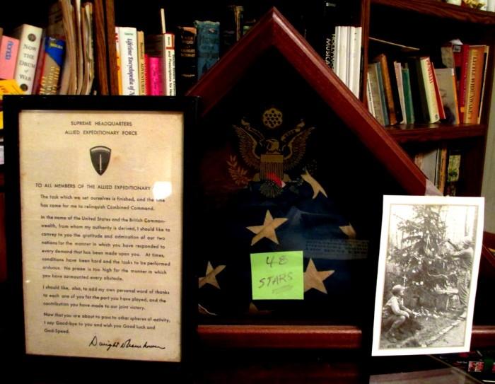 48 star flag inside presentation case for a veteran, framed declaration of thanks from General Eisenhower, old picture of soldiers spending Christmas in the field  decorating a pine tree.