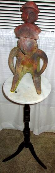 curious primitive style statuary on marble top pedestal table