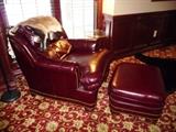 HANCOCK AND MOORE BURGUNDY LEATHER ARMCHAIR AND OTTOMAN WITH NAILHEAD DETAIL.