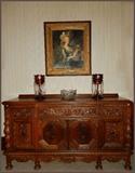 Oak side board.  Old framed print of woman. Ruby and crystal candle lights.