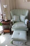 High back arm chair and matching foot stool. Antique end table/magazine rack.