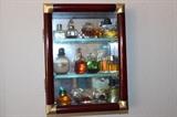 Miniature wall curio with miniature perfumes.