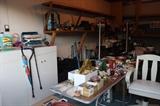 Storage cabinets, vintage Christmas, luggage, rolling wooden desk chair in the garage.
