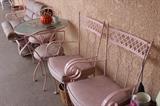 Pink iron patio furniture and a two seat glider.