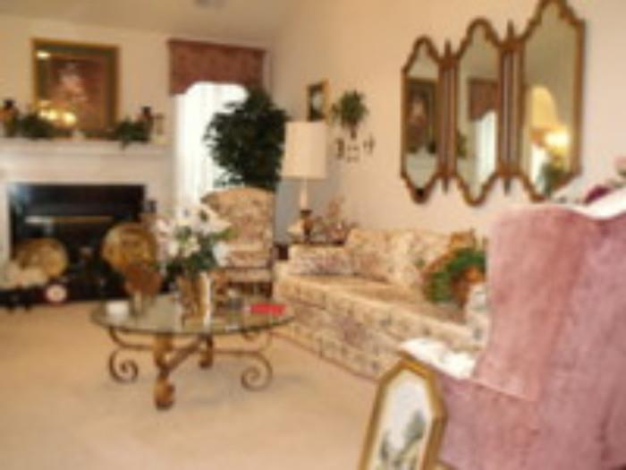 Sofa with two matching wing chairs, round coffee table with many decorative items