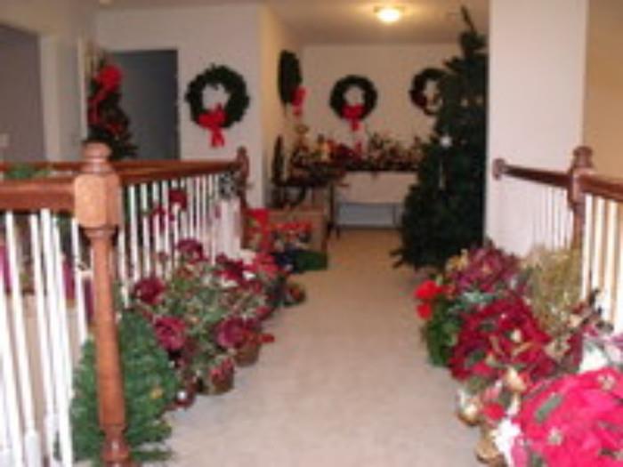 many Christmas floral arrangements and two Christmas trees