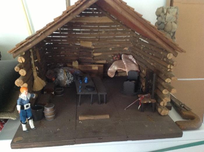 A log cabin doll house with removable front wall.