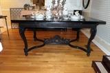 PAINTED BLACK TABLE WITH ORNATE TRESTLE BASE AND RETRACTIBLE LEAVES