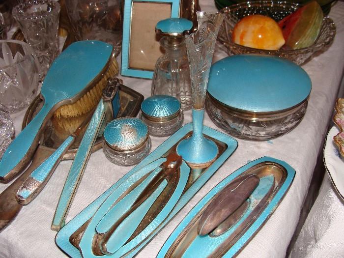 Blue enamel vintage vanity items including mirror, brush and jars, perfume bottle and more items.