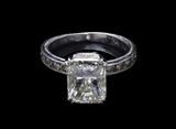 LOT 30: A RADIANT CUT DIAMOND AND PLATINUM RING
