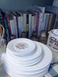 Set of vintage plates. Various cookbooks in background. 