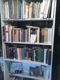 Book case in garage, filled with books vintage and newer.