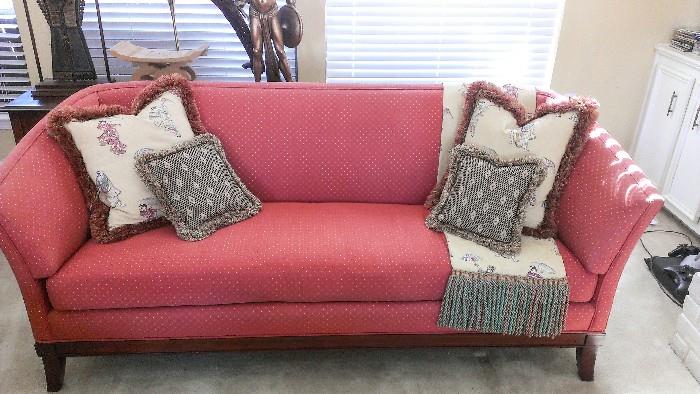 Red tuxedo sofa with decorative, reversible throw and pillows