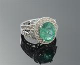 Lot 1028:  EMERALD & DIAMOND RING: 14K white gold ring centering a 3.92 Ct oval modified brilliant cut natural emerald with a halo of diamonds. Diamonds are also in the split shoulders setting. There are 42 diamonds totaling approx. 1.05 Ct., I1-I2 clarity and K-L color. Size 7. Weight 9.30 grams. Sold with Global Gem Labs GIA graduate gemologist appraisal for $12,430. Est. $4000/12400**