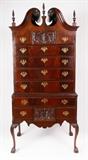 Lot 1082:  19TH CENTURY MAHOGANY CHIPPENDALE STYLE HIGHBOY: Mid 19th century, flame mahogany veneer all over. Broken arch pediment with rosettes, 2 spire finials. Top central drawer with carved shell front surmounted by 2 shaped drawers over 4 full length graduated drawers. Base with full length drawer over 3 drawer, center having matching shell decoration. Brass batwing pulls and escutcheons. Shaped skirt, cabriole legs with carved knees ending in claw and ball feet.
CONDITION: Crazing to veneer, age split to pediment, trim on base with missing corner, chips. Other wear consistent with age and use. Nails appear to be 1790-1835 vintage.