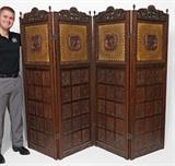 Lot 1149:  MARSHALL CUTLER CARVED ITALIAN RENAISSANCE REVIVAL FLOOR SCREEN: Each of the 4 panels with carved crest with figures over caned screen with central medallion with shield, backed with yellow silk. Lower section with carved foliate motif panels. Each panel 72'' h. x 23 1/2''.
CONDITION: Areas of splitting to caning, missing 2 finials, other wear consistent with age and use.