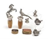 Lot 1311:  COLLECTION OF SILVER OBJETS DE VERTU: An assembled collection to include 1) Pair of figural wine corks with sterling mounted horse and pheasant, 5'' long overall. 2) Pair continental silver bird place weights, obscured hallmark, fineness unknown, 1 1/2'' h. 3) Bull and matador place weights, marked 916/1000 and obscured hallmark, matador 1 1/8''. Sold with 2 brass mounted pill boxes with hinged lids, one with inset agate, the other amber glass. 1 3/8'' x 1 1/8''.
