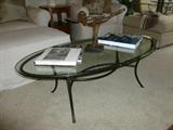 Iron base glass top coffee table adorned with some wonderful art books and fantastic sculptur
