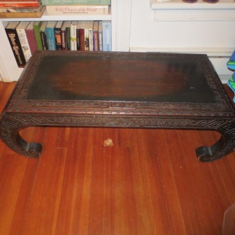 Dark teakwood Oriental style coffee table with a carved border and oriental C scroll legs 