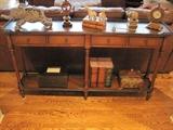 A pair of leather topped sofa tables and decor items.