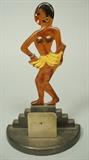 Lot 40:  JOSEPHINE BAKER Celluloid Art Deco Match Holder. Mounted on stepped wood base. Metal earring, bracelet and ta ta details. : Dimensions:  H: 7.75 inches: W: 4.75 inches: D: 2.5 inches --- US Shipping charge: $20