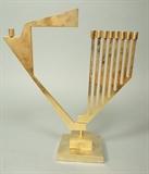 Lot 97:  Brass Menorah. Candelabra form with hinged pivoting candle holder, signed with illegible name, 136/480. Paper label reads SAMSON Gold Plate ONGVORI. : Dimensions:  H: 12.5 inches: W: 10.75 inches: D: 4 inches --- 