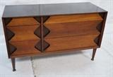 Lot 150:  Modernist Three Drawer Dresser GROSFELD HOUSE. Three Drawers with contrasting color shaped fronts. Peg legs. Marked. : Dimensions:  H: 30 inches: W: 48 inches: D: 19 inches --- 