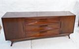 Lot 218:  American Modern Low Dresser Credenza. Deep triangular shaped details to drawer fronts. Horizontal wood pulls. Three Drawer. Two Doors with interior drawers.: Dimensions:  H: 32.25 inches: W: 73.5 inches: D: 19 inches --- 