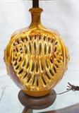 Lot 246:  Large Mustard High Gloss Pottery Table Lamp. Modernist Lamp with rows of pierced swags. Wood details. Ceramic only: 18"H x 16"W: Dimensions:  H: 41 inches: W: 16 inches --- 
