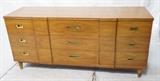 Lot 249:  WIDDICOMB Modernist Low Dresser Credenza. Nine Drawers with recessed brass pulls. Shaped fronts. Brass foot caps. Marked: Dimensions:  H: 32.25 inches: W: 70.5 inches: D: 21.5 inches --- 