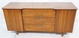 Lot 256:  American Modern Sideboard Credenza Two doors with sculpted fronts. Three center drawers. Shaped front. Metal pulls. Not marked. : Dimensions:  H: 30.5 inches: W: 62 inches: D: 20 inches --- 