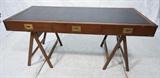 Lot 272:  Campaign style desk on sawhorse form legs. Leather top. Brass trim to sides. recessed brass drawer pulls.: Dimensions:  H: 29.5 inches: W: 66 inches: D: 28 inches --- 