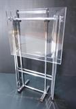 Lot 285:  Lucite Folding TV Tables on Chrome Stand. Modernist design stand holds two collapsible trays. : Dimensions:  H: 30.5 inches: W: 19 inches: D: 8 inches --- 