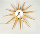 Lot 336:  HOWARD MILLER Starburst Wall Clock. GEORGE NELSON. Walnut spokes. Marked: Dimensions:  H: 19 inches: W: 19 inches: D: 2.75 inches --- US Shipping charge: $35