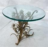 Lot 388:  Decorator Italian Iron Low Side Table. Glass Top. Gilt iron leaves with white floral accents. : Dimensions:  H: 21 inches: W: 24 inches --- 