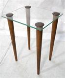 Lot 405:  GILBERT ROHDE glass top side end table. Tall tapered peg legs with metal caps. : Dimensions:  H: 25.75 inches: W: 18.5 inches: D: 16 inches --- 