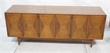 Lot 463:  Low Walnut American Modern Credenza. Hourglass shaped veneer design.  Metal knob pulls. Peg Legs: Dimensions:  H: 25.75 inches: W: 66.6 inches: D: 19 inches --- 