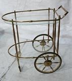 Lot 511:  Decorator Brass and Wood Bar Cart.  Glass shelves.  Large wheels.: Dimensions:  H: 36 inches: W: 33.5 inches: D: 20 inches --- 