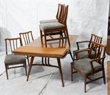 Lot 573:  American Modern Walnut Dining Table. 6 Chairs. Table with angled tapered legs with decorative supports. Three 12" leaves.: Dimensions:  H: 29.75 inches: W: 60 inches: D: 40 inches --- 