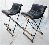Lot 580:  Pr Iron & Wood Bar Stools. Black vinyl sling seats. CLEO BALDON: Dimensions:  H: 38 inches: W: 19 inches: D: 24 inches --- 
