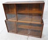 Lot 652:  2pc Bookcase China Tops. American Modern Wood. Glass Doors: Two small doors. Two Large. : Dimensions:  H: 24.5 inches: W: 54 inches: D: 12 inches --- 