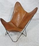 Lot 707:  Leather Folding Iron Butterfly Chair. Natural tanned leather.: Dimensions:  H: 36 inches: W: 30 inches: D: 31 inches --- 