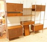 Lot 720:  3 Section Founders Wall Unit. Walnut Cabinets & shelves. Aluminum Supports. Three Cabinets with woven doors. Two drawers. Six shelves.: Dimensions:  H: 83 inches: W: 96 inches --- 