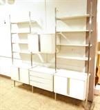 Lot 723:  OMNI White Laminate Wall Shelf Unit. Aluminum Uprights. 3 Laminate Cabinets with aluminum accents. One Section with three drawers. Nine shelves.: Dimensions:  H: 89.5 inches: W: 93 inches: D: 15 inches --- 