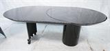 Lot 812:  ROUGIER Black Lacquer Oval Dining Table. Two leaves: unique curved leaf system. Base has wheels. Marked.: Dimensions:  H: 29 inches: W: 73 inches: D: 44 inches --- 