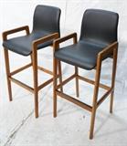 Lot 827:  Pr Danish Modern Teak Bar Stools with Arms. Tall Backs. Black vinyl seats. : Dimensions:  H: 44 inches: W: 19 inches: D: 22 inches --- 