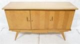 Lot 833:  Modernist Blond Wood Three Door Credenza. Tapered peg legs. Decorative sides and skirt.: Dimensions:  H: 37 inches: W: 60 inches: D: 20 inches --- 